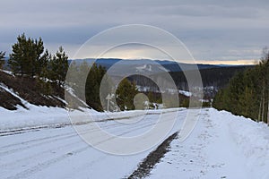 Winter paved road leading to snow covered mountains