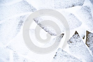 Winter pavement background. Snow covered wild stone paving tiles
