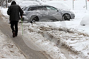 Winter. People walk on a very snowy roads. People step on an snow-stray pathway. Icy sidewalk. Ice on sidewalks