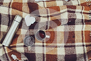 Winter picnic on the snow. Hot tea, thermos and snowball heart on cozy warm blanket.