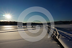 Winter pier frozen water at sunrise