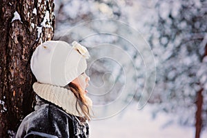 Winter portrait of adorable child girl in grey fur coat in snowy forest