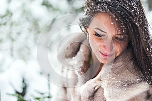 Winter portrait of a beautiful woman in fur coat outdoors.