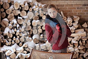 Winter portrait of blonde woman on firewood background