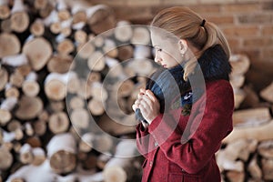 Winter portrait of blonde woman on firewood background