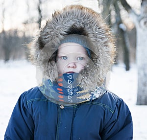 Winter portrait of a child in the hood with fur