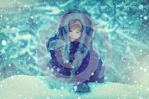 Winter portrait of cute child in snow Garden. Joyful child Having Fun in Winter Park. Children in winter park. Kids