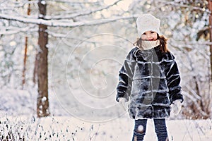 Winter portrait of cute happy child girl in grey fur coat