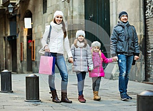 Winter portrait of happy adults with daughters . Focus on woman and ittle girl