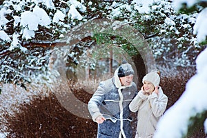 winter portrait of happy couple having lot of fun and throwing snow outdoor