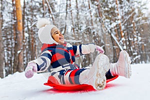 Winter portrait of happy little girl wearing knitted hat and a jumpsuit outdoor in winter