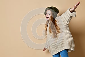 Winter portrait of happy little girl wearing knitted hat and sweater.