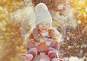 Winter portrait happy smiling little girl child outdoors on snowy background