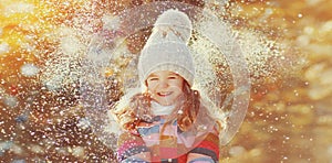 Winter portrait of happy smiling little girl child outdoors on snowy background