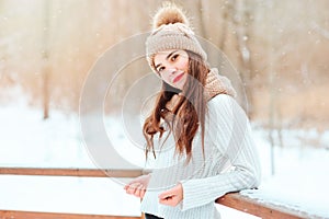 winter portrait of happy young woman walking outdoor in snowy park