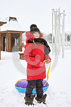 Winter portrait of a little girl with tubing
