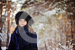 Winter portrait of smiling child girl in fur hat and coat