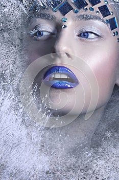 Winter Portrait.Snow Queen, creative closeup portrait. Young woman in creative image with silver artistic make-up and blue lips.