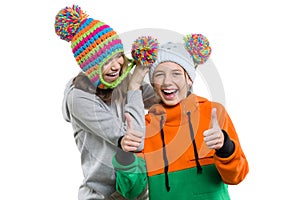 Winter portrait of two happy smiling pretty girls in knitted hats having fun, isolated on white background, people, youth and frie