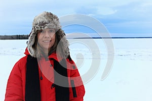 Winter portrait of a woman wearing an furry aviation hat and red jacket