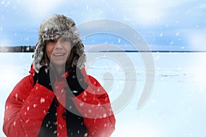 Winter portrait of a woman wearing an furry aviation hat and red jacket