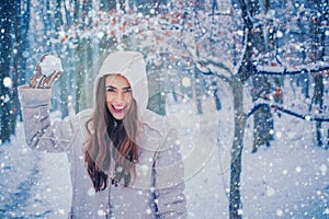 Winter portrait of young beautiful brunette woman in snow Garden. People in snow. Woman winter portrait.