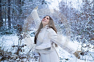 Winter portrait of young beautiful brunette woman in snow Garden. Winter concept. Winter woman fan.