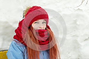 Winter portrait of young beautiful womah in red hat and red comforter