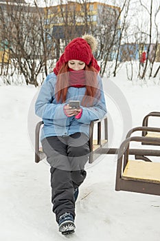 Winter portrait of young beautiful womah in red hat and red comforter