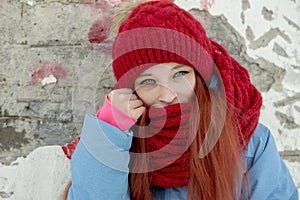 Winter portrait of young beautiful woman in red hat and red comforter