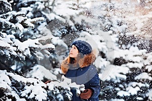 Winter portrait: Young pretty girl dressed in a warm woolen clothes, scarf and covered head posing outside.