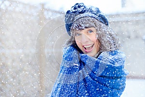 Winter portrait of a young woman. Beauty Joyous Model Girl touching her face skin and laughing, having fun in the winter park. Bea