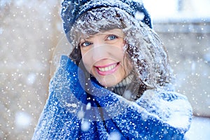 Winter portrait of a young woman. Beauty Joyous Model Girl touching her face skin and laughing, having fun in the winter park. Bea