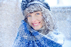 Winter portrait of a young woman. Beauty Joyous Model Girl touching her face skin and laughing, having fun in the winter park. Bea