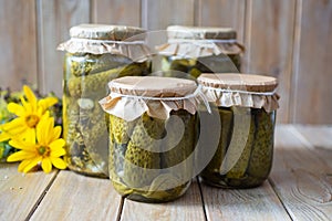Winter preservation: pickled cucumbers with spices and dill in glass jars on a wooden table. Close-up