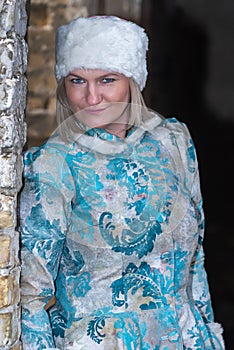 Winter queen in an abandoned castle. A beautiful woman in a winter suit