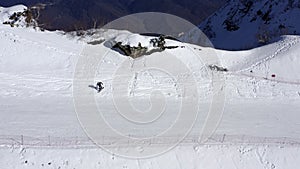 Winter resort in mountain aerial view. Snowboarder snowboarding on snowy slope