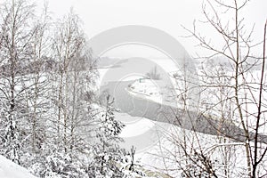 Winter river on a background of a snowy landscape, blizzard, background. Beautiful nature