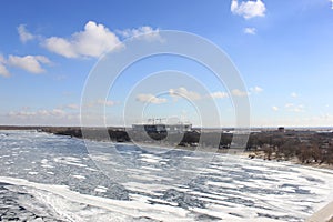 Winter river covered with ice with blue cloudy sky