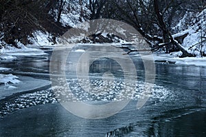 Winter river between old trees