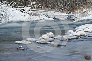 Winter river surface with snow crystals and ice floating on water - long exposure photo, surface is silky smooth