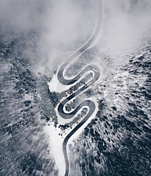 Winter road in the forest. Aerial view the a winding mountain road at Cheia, Romania photo