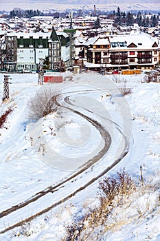Winter road, houses with snow roofs panorama in bulgarian ski resort Bansko