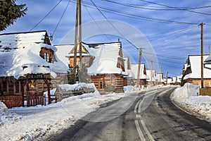 Winter road in polish village valley with old wooden houses. Tatra Mountains