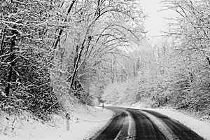 Winter road with snow on the ground. travel in difficult way to enjoy the colder season. white image with black asphalt in photo