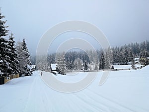 Winter road in the village with snow, and kid sking