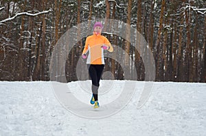 Winter running in forest: happy woman runner jogging in snow, outdoor sport and fitness