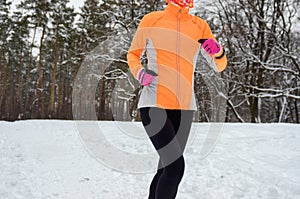 Winter running in forest: happy woman runner jogging in snow, outdoor sport and fitness