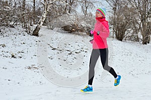 Winter running in park: happy woman runner jogging in snow