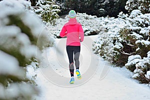 Winter running in park: happy woman runner jogging in snow, outdoor sport and fitness